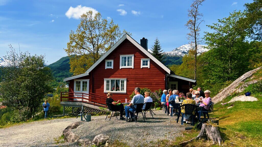 Customers sitting outside Annas Kafé, a cafe on Tinghaug, Sauda on a warm, sunny summer's day.