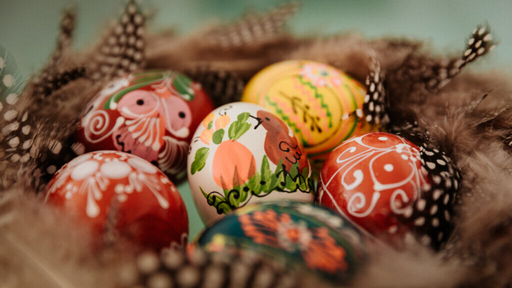 Closeup of decorated Easter eggs in a nest of feathers.