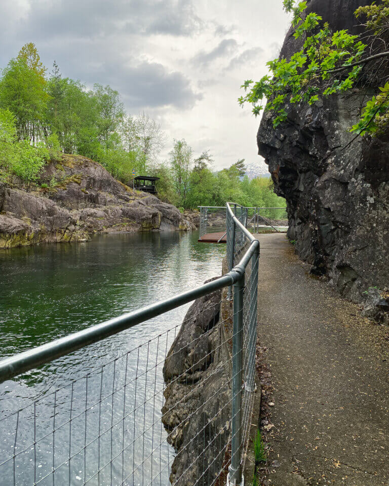 A walkway with fence by a river in summer in Sauda, Norway.