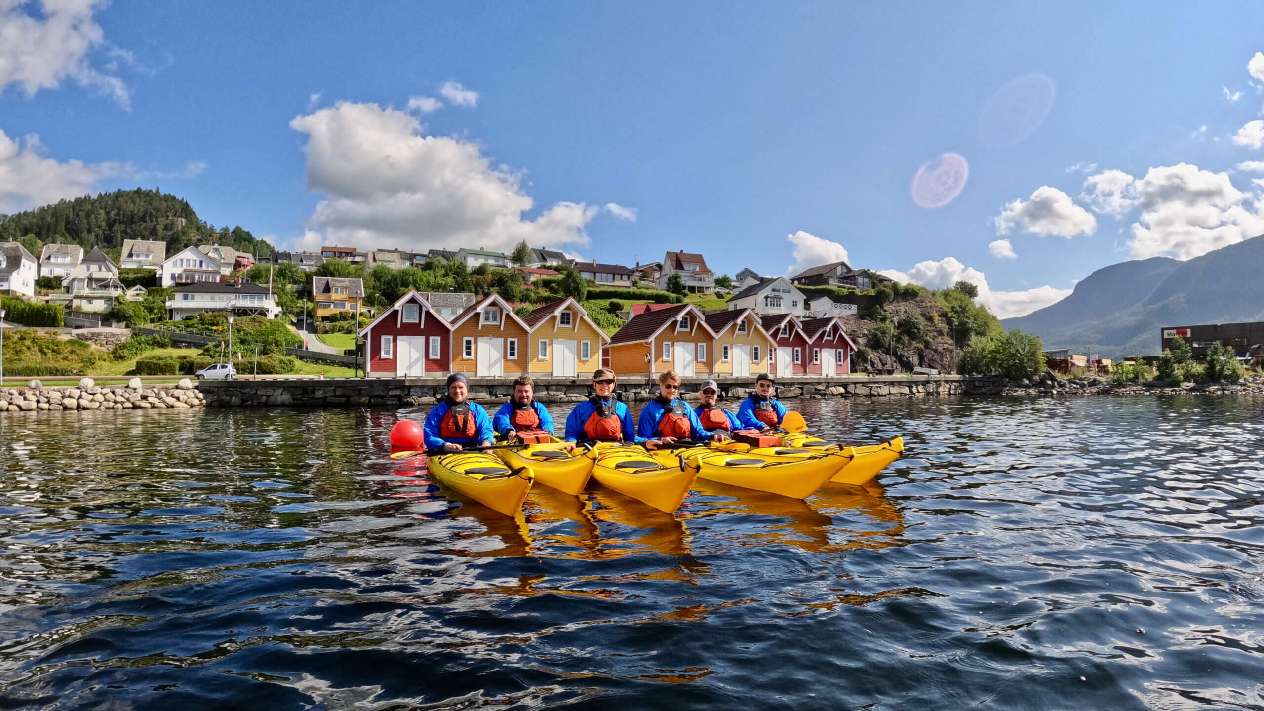 Four people in sea kayaks on the fjord in Sauda